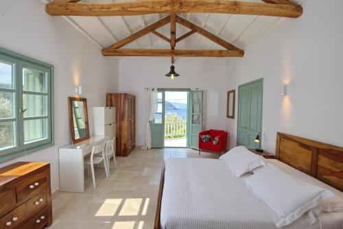 a bedroom with a bed and a table and a refrigerator at Villa Aquilo in Megali Ammos
