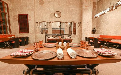 a wooden table with plates and napkins on it at Welcomhotel by ITC Hotels, Bhubaneswar in Bhubaneshwar