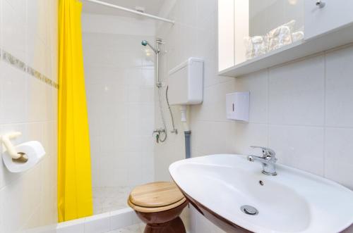 een witte badkamer met een wastafel en een douche bij DADA in Novi Vinodolski