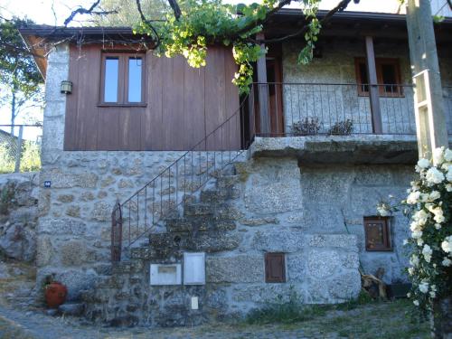 a stone house with a staircase in front of it at Casa do Faroca in Vieira do Minho