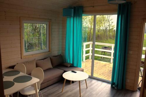 a living room with a couch and a table at Zaciszne Gąski - domki letniskowe in Gąski