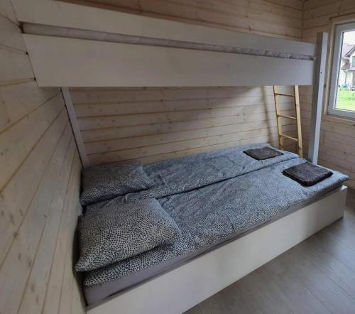 a bedroom with a bed in a wooden room at Zaciszne Gąski - domki letniskowe in Gąski