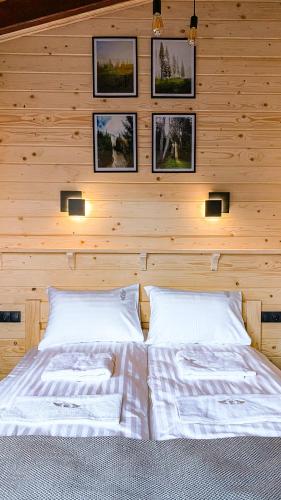 a bedroom with two beds and pictures on the wall at Апартаменти Стара Ворохта in Vorokhta