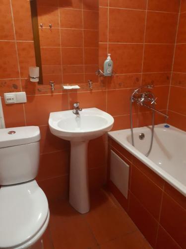 a bathroom with a toilet and a sink and a bath tub at Dniprovski Zori in Kremenchuk