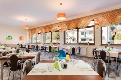 een restaurant met tafels, stoelen en ramen bij OW Diament in Pobierowo