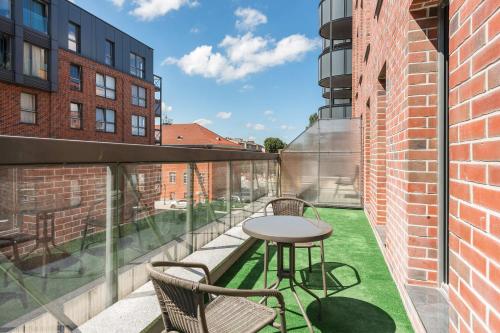 a balcony with a table and chairs on a brick building at Browar Gdanski Budget by Renters in Gdańsk