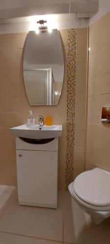 a bathroom with a sink and a toilet and a mirror at GrandVille Apartments in Bucharest
