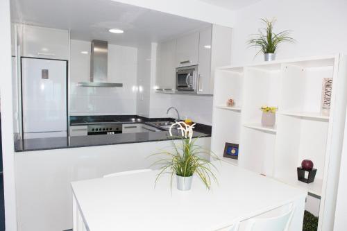 a kitchen with white walls and a white counter top at Rentyplus Mar Azul MangaNorte in La Manga del Mar Menor