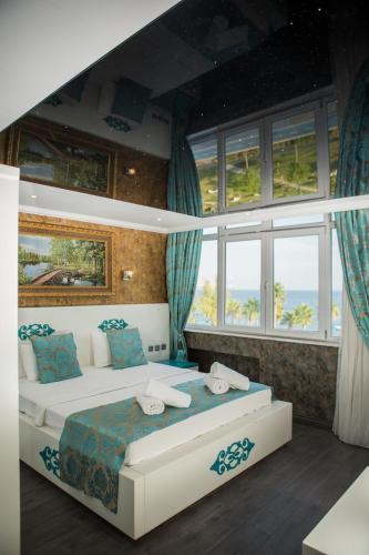 a bedroom with a bed in a room with windows at ERDEM HOTEL in Antalya