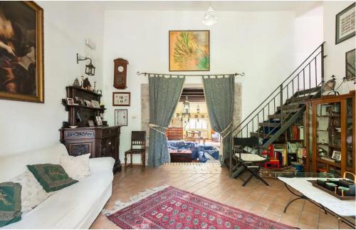 sala de estar con sofá y escalera en Casale Gli Angeli-Charming Villa with Garden and Parking!, en Gubbio