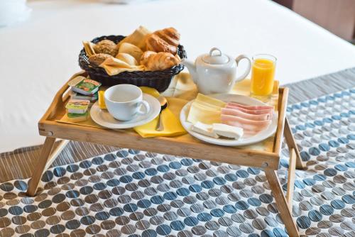 a tray of breakfast foods and coffee on a table at Golden Tulip São João da Madeira in São João da Madeira
