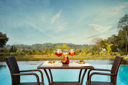 a table with two glasses of red wine on it at Rosetta Sakleshpur in Sakleshpur