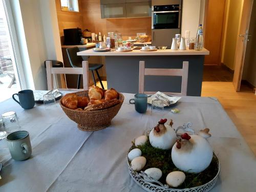 a table with two chickens and a basket of bread at B&B Caprice d'Epices in Francorchamps