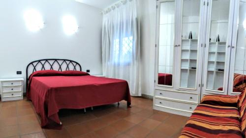 ポルト・サン・パーオロにあるVilla Raffaelloのベッドルーム1室(赤いベッドカバー付)