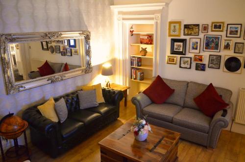 a living room with two couches and a mirror at Heart of Ayr: elegant townhouse in central Ayr in Ayr