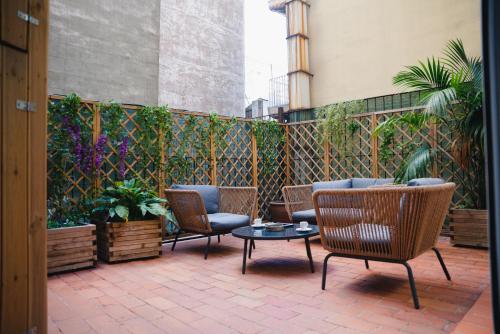 eine Terrasse mit Stühlen, einem Tisch und einem Zaun in der Unterkunft Cosmopolitan Boutique Rambla in Barcelona