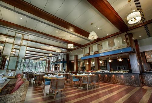 a restaurant with tables and chairs and a bar at Rosetta Sakleshpur in Sakleshpur