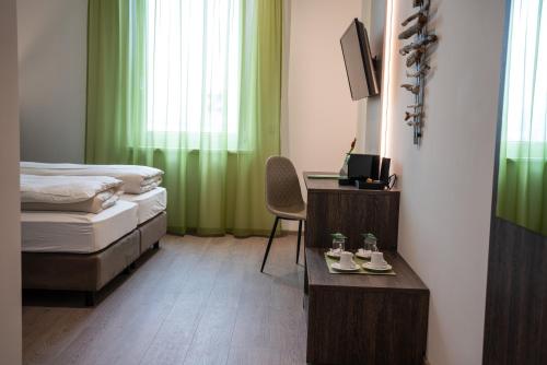 a bedroom with a bed and a desk with a chair at eee Hotel Graz in Neupirka