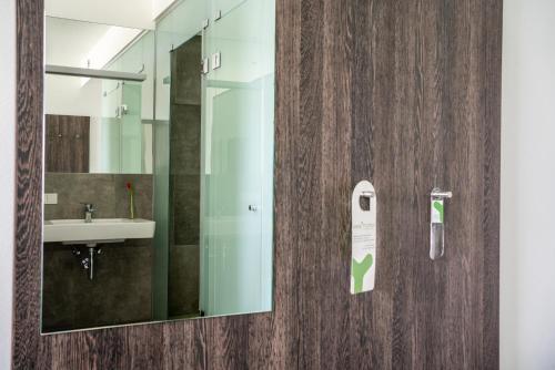 bagno con lavandino e specchio di eee Hotel Graz a Neupirka