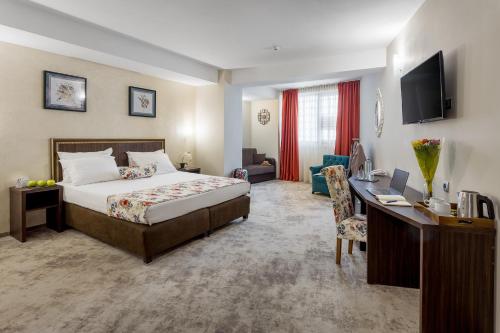 a hotel room with a bed and a desk at Prestige Boutique Hotel Craiova in Craiova