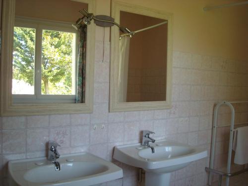 La salle de bains est pourvue de 2 lavabos, d'un miroir et d'une fenêtre. dans l'établissement La Tour des Laudes, à Breuil-Barret