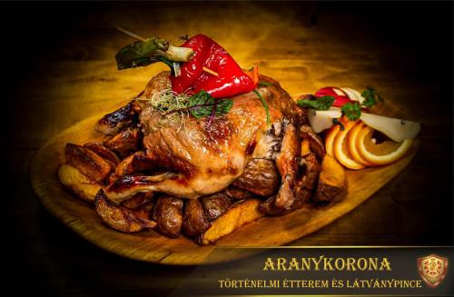 a plate of food with a chicken and vegetables at Aranykorona Hotel in Miskolc