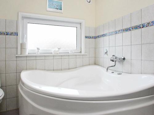 a white bath tub in a bathroom with a window at 10 person holiday home in Løkken-By Traum in Løkken