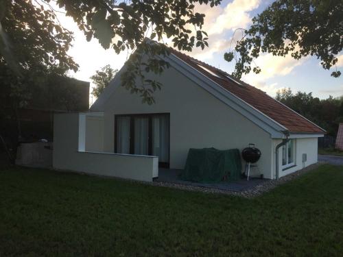 een klein wit huis met een tafel ervoor bij Ferienhaus Kaept n Poldi 25192 in Bunde