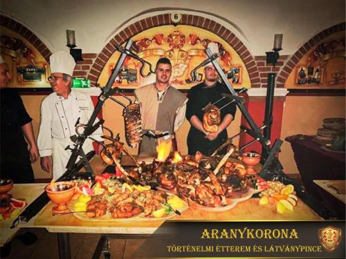 a group of people standing around a table with food at Aranykorona Hotel in Miskolc