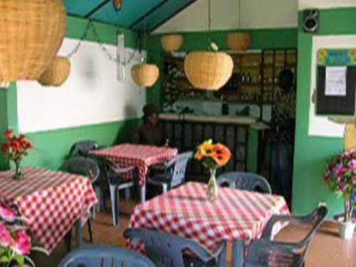 a restaurant with tables and chairs with flowers on them at Hotel Marie Antoinette Lome in Lomé