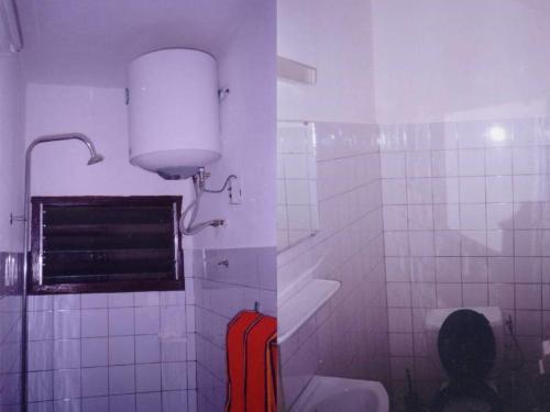 uma casa de banho com WC e uma luz na parede em Hotel Marie Antoinette Lome em Lomé