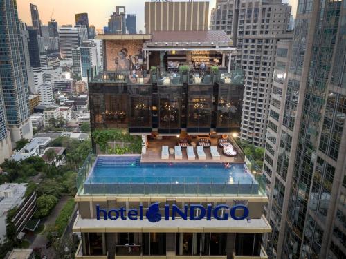 a hotel indigo building with a swimming pool at Hotel Indigo Bangkok Wireless Road by IHG in Bangkok