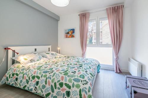a bedroom with a bed with a colorful comforter and a window at Le Levantés par Dodo-a-Cassis in Cassis
