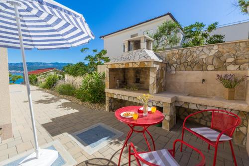 a patio with a table and two chairs and an umbrella at DAKOVIC TIHANA in Šilo