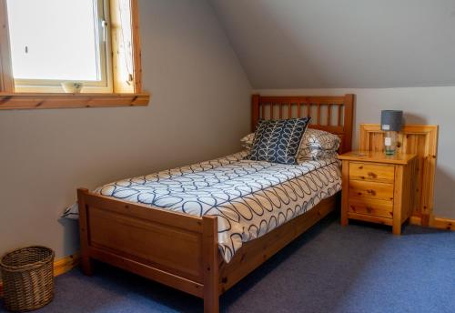 een slaapkamer met een bed, een dressoir en een raam bij Ar Dachaigh, North Uist in Paible