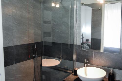 a bathroom with a sink and a glass shower at Affittacamere Delfo in Pisa