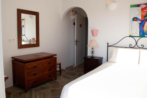 a bedroom with a bed and a dresser and a mirror at Agkeria great feeling house in Kampos Paros