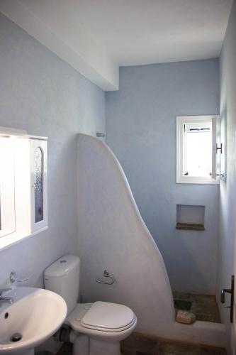 a white bathroom with a sink and a toilet at Agkeria great feeling house in Kampos Paros