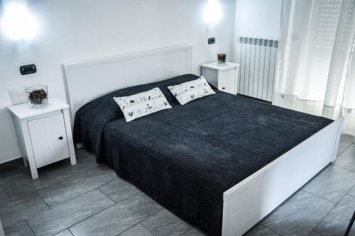 a bedroom with a large bed with two white tables at Affittacamere Delfo in Pisa