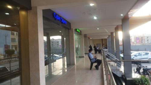 a man sitting in a chair in a building at Maple Leaf Hotel in Kharar