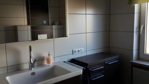 a bathroom with a sink and a mirror at Ferienwohnung Steimer in Langgöns