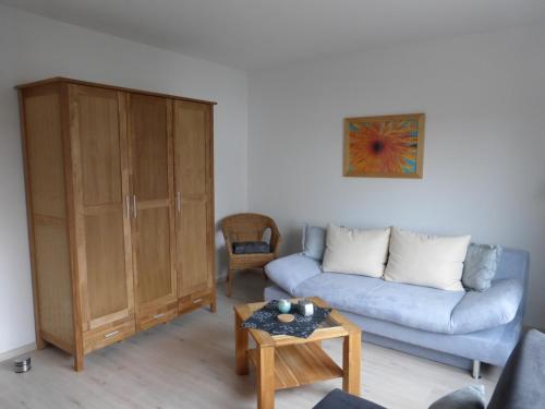 uma sala de estar com um sofá e um armário em Ferienwohnung Steimer em Langgöns