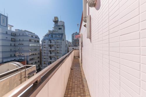 a brick walkway in a city with tall buildings at Tabist Hotel Florida Ikebukuro in Tokyo