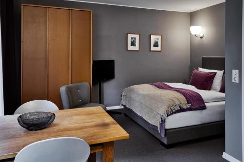 una camera con letto, tavolo e sedie di STAY Boardinghouse Flottbek ad Amburgo