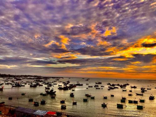 a group of boats in the water at sunset at Hoang Nga Garden Guesthouse in Mui Ne