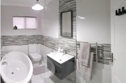 La salle de bains blanche est pourvue d'un lavabo et de toilettes. dans l'établissement Kleinmond - Fairview on First, à Kleinmond