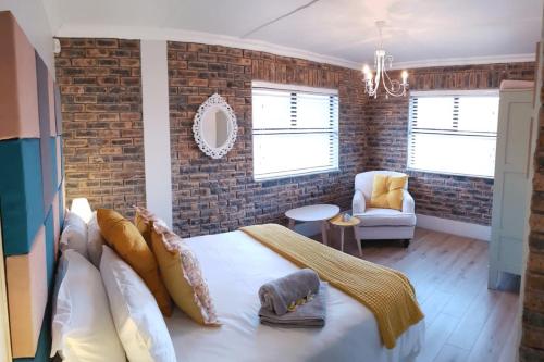 - une chambre avec un lit et un mur en briques dans l'établissement Kleinmond - Fairview on First, à Kleinmond