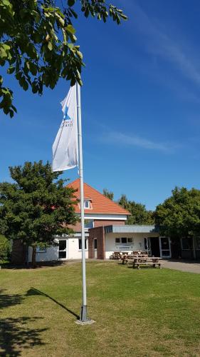 a white flag on a pole in front of a building at Jugendherberge Fehmarn in Fehmarn