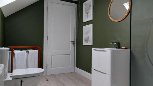 a bathroom with a toilet and a sink and a mirror at Finn Loft in Ballybofey