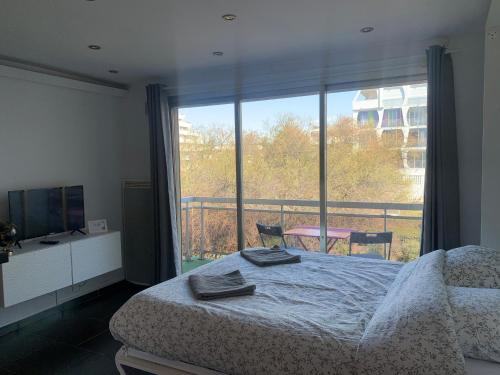 une chambre avec un lit et une grande fenêtre dans l'établissement Les Appartements De Lina By JO - Self Check-In, à La Grande Motte